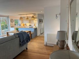 A living room with a dining table and kitchen view at Red Wharf Retreat near Red Wharf Bay