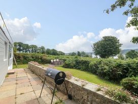 A garden with a barbecue and outdoor seating at Red Wharf Retreat near Red Wharf Bay