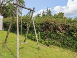 A swing set in the garden at Red Wharf Retreat near Benllech