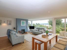 A living room with a sofa and dining table at Red Wharf Retreat near Red Wharf Bay