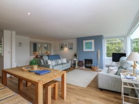 A living room with a sofa, dining table and TV at Red Wharf Retreat in Red Wharf Bay near Benllech