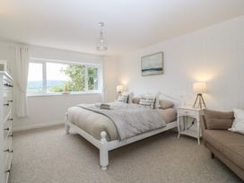 A bedroom with a bed and nightstand at Red Wharf Retreat in Red Wharf Bay near Benllech