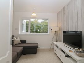 A living room with a sofa and television at Red Wharf Retreat near Red Wharf Bay