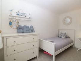 A bedroom with a bed and dresser at Red Wharf Retreat Red Wharf Bay near Benllech