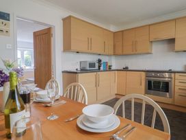 A kitchen with wooden cabinets and dining table at Seaview in Lyme Regis