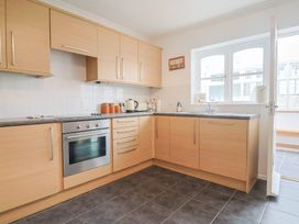 A kitchen with cabinets oven and sink at Seaview in Lyme Regis