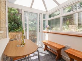 A conservatory with a table and benches at Seaview in Lyme Regis