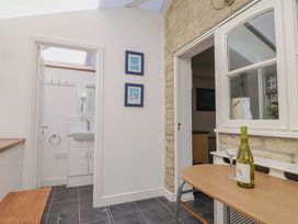 A conservatory with a table and wine glasses at Seaview in Lyme Regis