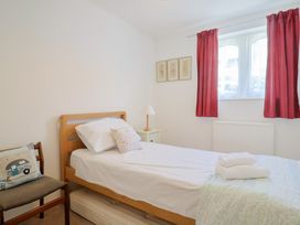 A bedroom with a bed, lamp, and chair at Seaview in Lyme Regis