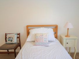 A bedroom with a bed, chair, and lamp at Seaview in Lyme Regis