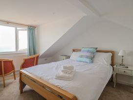 A bedroom with a bed and two chairs at Seaview in Lyme Regis
