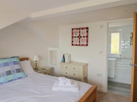 A bedroom with a bed and bathroom access at Seaview in Lyme Regis
