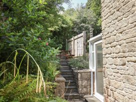 A garden with stairs leading to a table and plants at Seaview in Lyme Regis