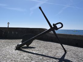 An anchor on cobblestones near the sea at Seaview in Lyme Regis