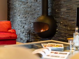 A living room with a fireplace and a red sofa at Prospect House Windermere