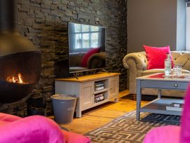 A living room with a fireplace and television at Prospect House in Windermere