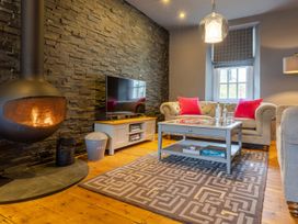 A living room with a fireplace and television at Prospect House in Windermere