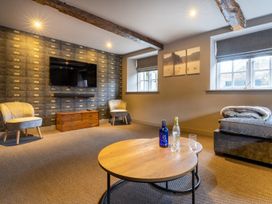 A living room with a television and armchairs at Prospect House in Windermere