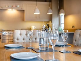 A dining room with a table set for dinner at Prospect House in Windermere