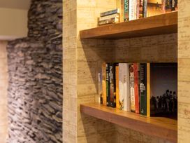 A bookshelf with various books in a reading area at Prospect House in Windermere