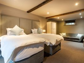 A bedroom with two beds and a wardrobe at Prospect House in Windermere