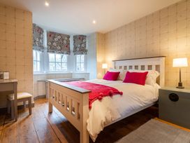 A bedroom with a double bed and chair at Prospect House Windermere
