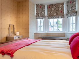 A bedroom with a bed and mirror at Prospect House in Windermere
