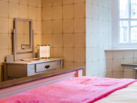 A bedroom with a vanity table and books at Prospect House in Windermere