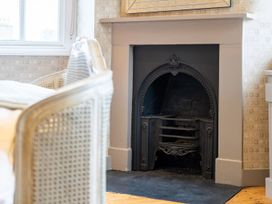 A fireplace and a chair with a cushion at Prospect House in Windermere