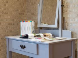 A vanity table with a mirror and books at Prospect House in Windermere