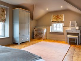 A bedroom with a wardrobe and desk at Prospect House in Windermere