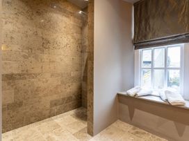 A bathroom featuring a shower and towels on a windowsill at Prospect House Windermere