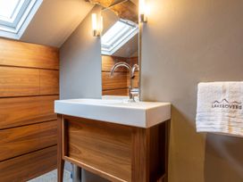 A bathroom with a sink and wooden paneling at Prospect House in Windermere