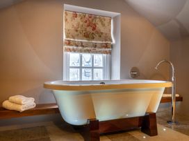 A bathroom with a bathtub and towels at Prospect House in Windermere