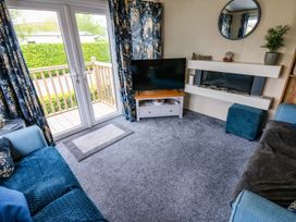 A living room with a television and sofa at Plot 41 High Hesket near Armathwaite