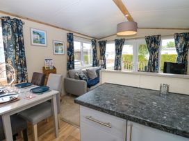 A living room with a dining area and a sofa at Plot 41 in High Hesket near Armathwaite