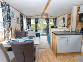 A living room with a dining area and kitchen counter at Plot 41 in High Hesket near Armathwaite