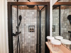 A shower area with patterned tiles and shower accessories at Stones Throw in Mevagissey