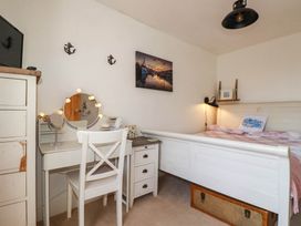 A bedroom with a bed and dressing table at Stones Throw in Mevagissey