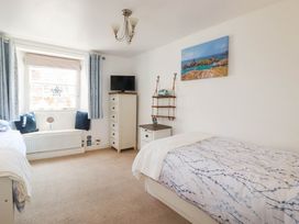 A bedroom with two beds and a dresser at Stones Throw in Mevagissey