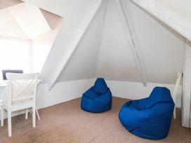 An attic with two blue bean bags and a chair at Stones Throw in Mevagissey
