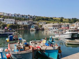 A harbor with boats and buildings in the background at Stones Throw Mevagissey