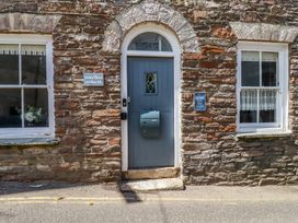 A stone wall with a blue door and windows at Stones Throw in Mevagissey