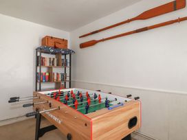 A game room with a foosball table and bookshelf at Stones Throw in Mevagissey