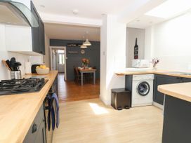A kitchen with a stove and washing machine at 19 Covert Road in Reydon
