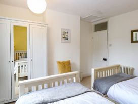 A bedroom with two beds and a wardrobe at 19 Covert Road in Reydon