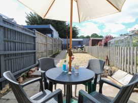 A garden with a table and chairs under an umbrella at 19 Covert Road Reydon