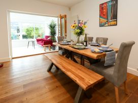 A dining room with a wooden table and benches at 29 Bincleaves Road, Weymouth