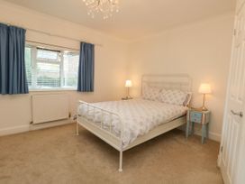 A bedroom with a bed, curtains, and a window at 29 Bincleaves Road in Weymouth