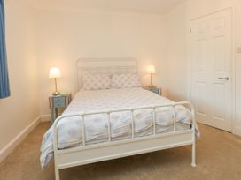 A bedroom with a bed, nightstand, and lamp at 29 Bincleaves Road, Weymouth